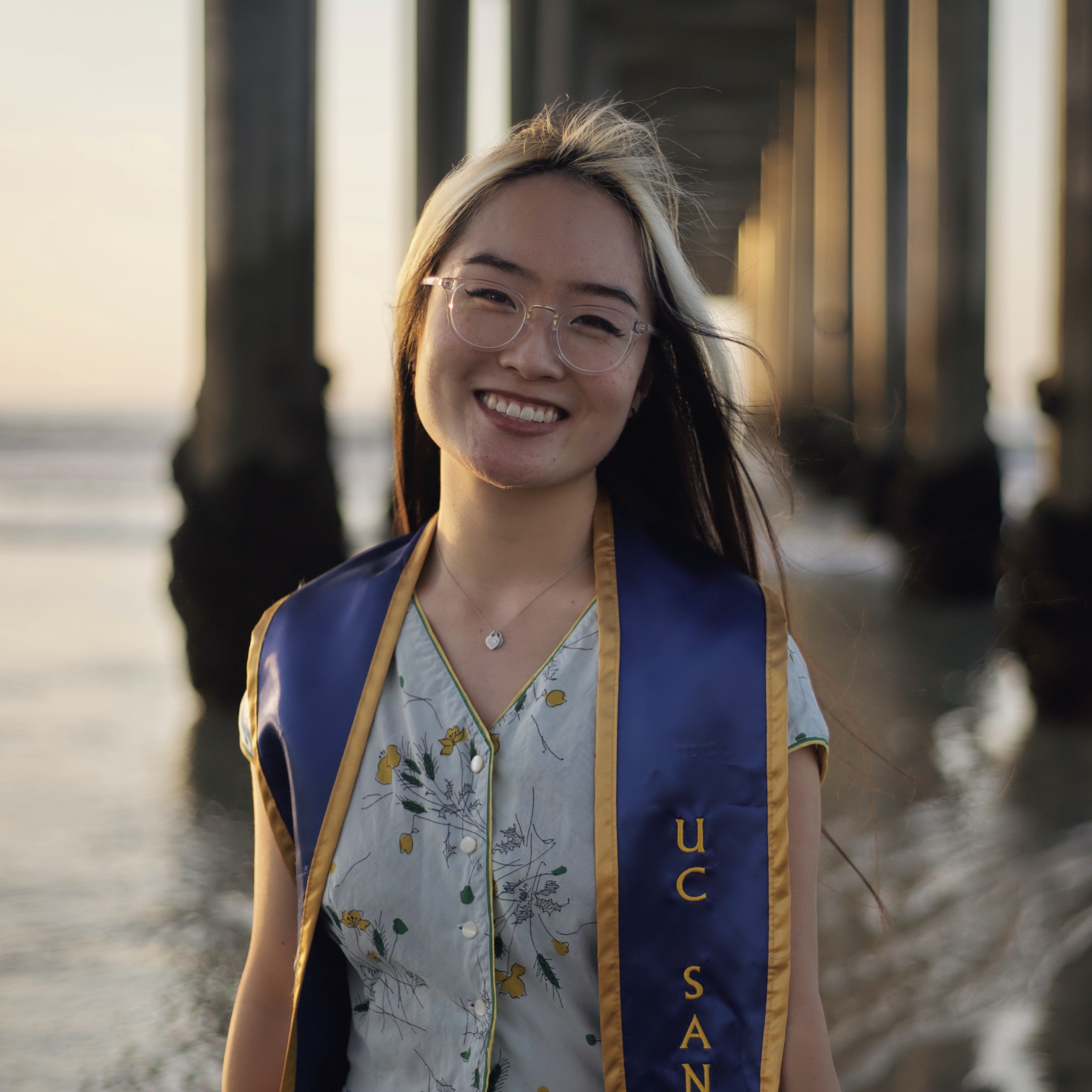Graduation picture of Kendall smiling in front of the ocean
